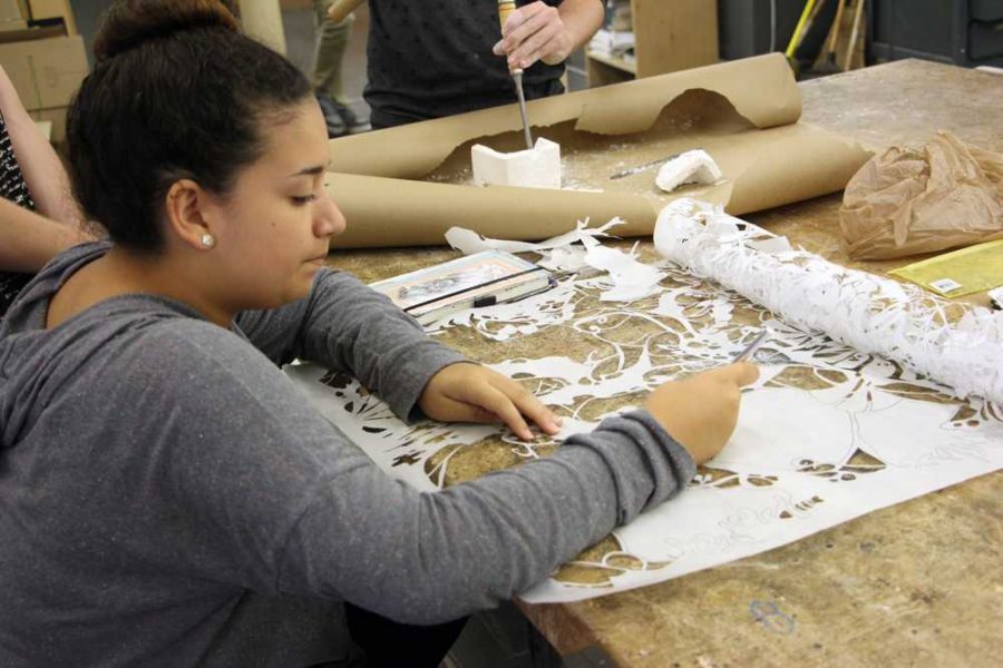 Visual arts junior Samantha Santana works on a stencil for a print. 