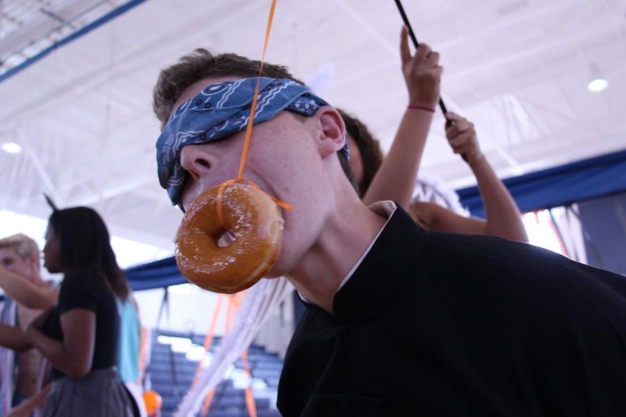 Communications  junior, Matthew Feuer, blindly attacks a donut in the Donut Eating contest during Fall Festival yesterday.