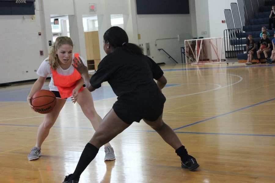 Visual junior Rachel Rabinowtiz and strings senior Giselle Grahm go head to head during the Powder Puff Basketball game.