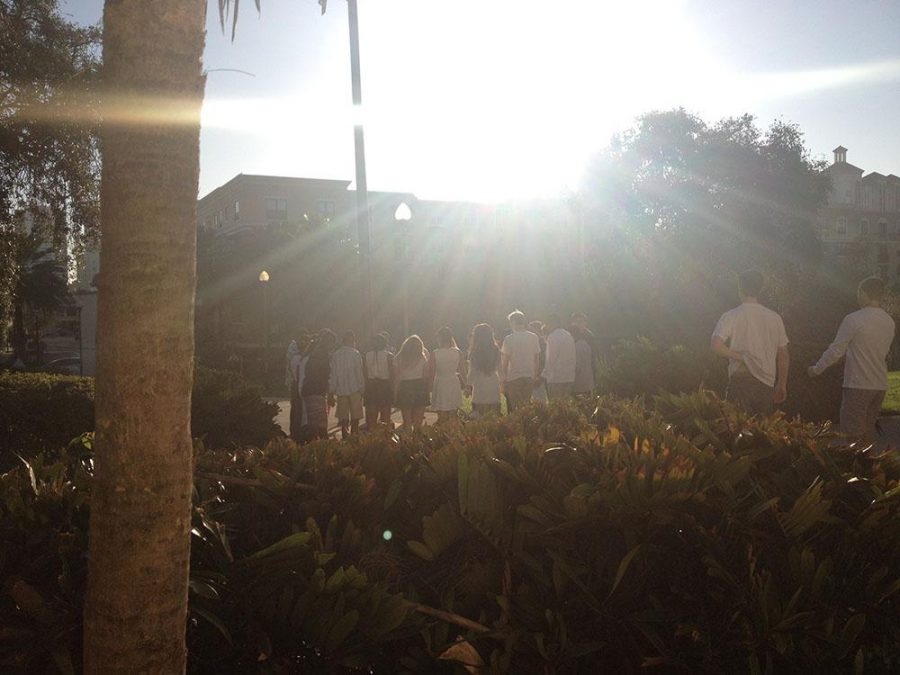 Students stand before the flag pole in prayer, in honor of Alex and Jackie Berman. 