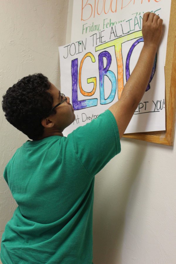 Communications senior Carson Baez-Smith hangs a poster encouraging students
to join The Alliance. The Alliance meets every Tuesday during lunch in English
teacher Martha Warwick’s room, room 3-104.