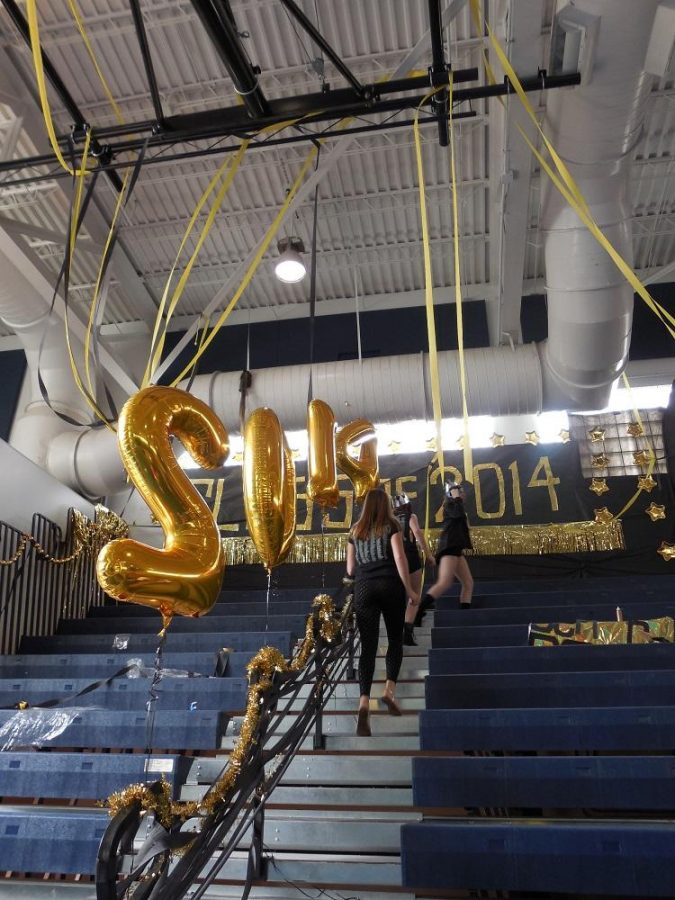 Members of the senior class council and SGA walk around in their crowns,
displaying their class theme “senior royalty” as they decorate their section of the
gym for the pep rally.