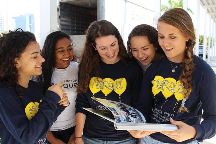 Rebecca Greenspan (from left), Ilani Fernandes, Co-Editor Rachel Frieary, Jordan McCrary and Co-Editor Casey Taranella get a glimpse of the first Yearbook off the truck Tuesday. Distribution will be April 30, May 1 and May 2. (Photo by Bethany Ebanks)