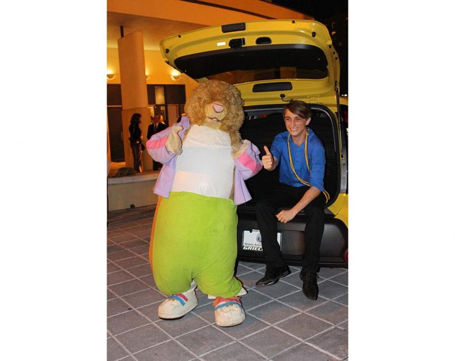 Theatre senior Dylan Cohen with the Kia mouse and his brand new car outside of Meyer Hall. 