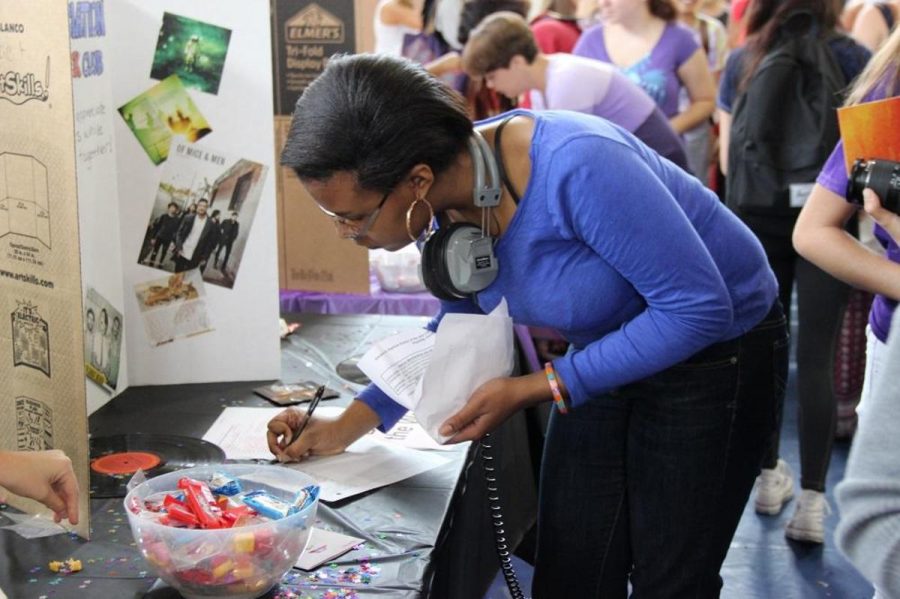 Student signs up for the Music Appreciation Club during club rush. 