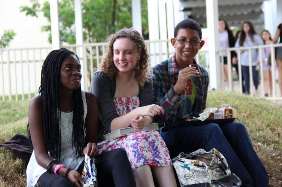 Students Destiny Robinson, (l-r) Noelle Wamsley and Samuel Calzada have lunch on the artificial hill by building 9. The hill began as an installation project by visual arts students last year and has fully integrated into the landscape this year. 