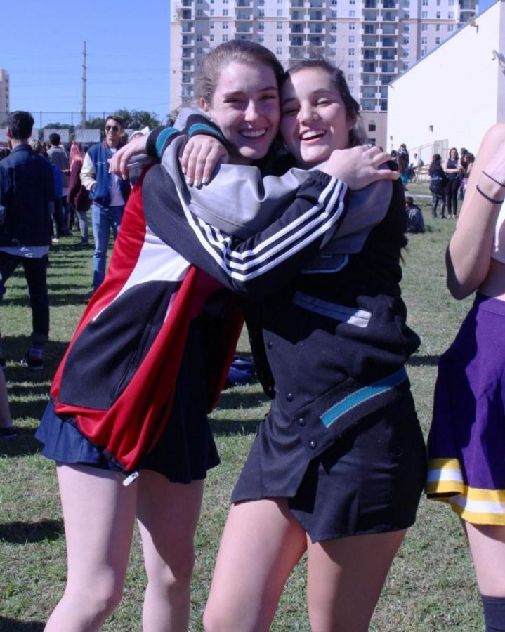 Band junior Riley Gore and digital media junior Valentina Suarez share a hug on the field as the classes complete activities during spirit week. 