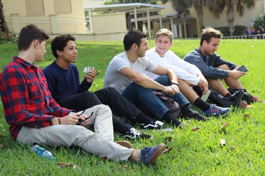 Digital media senior Brandon McMillan, digital media senior Cameron Bevans, communications senior Michael Santomaso, theatre senior John Hench, and communications senior Steffan Gawlikowski (L-R) converse atop Freshman Hill during their lunch period. 
