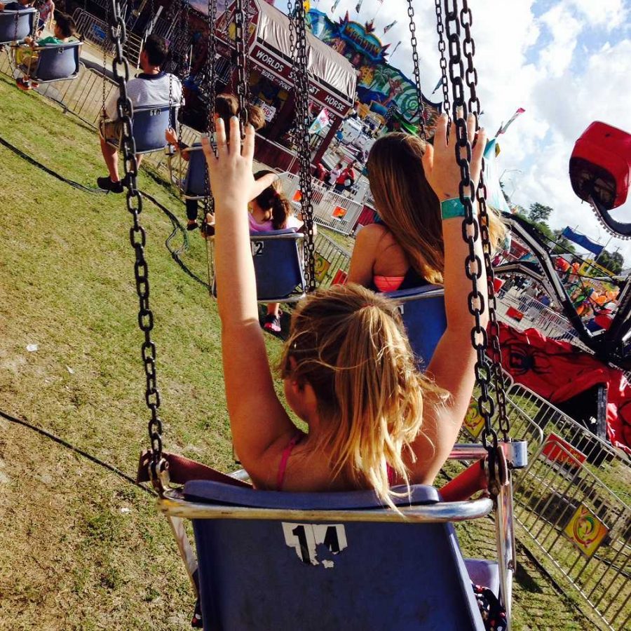 Jaida Ralph lifts her arms while riding the swings at the South Florida Fair to get a roller coaster effect. 