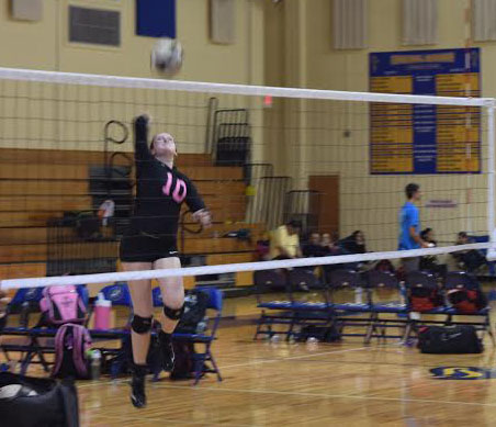 Band freshman Jamie Lynch spikes the ball at a game at Cardinal Newman High School against Big Lake. 