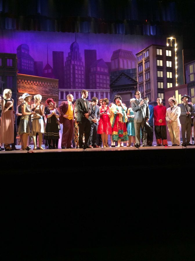 The cast of Thoroughly Modern Millie stands on stage with Tony award-winning producer Hal Luftig. Theatre junior Drew Lederman (center) holds Luftigs Tony award.