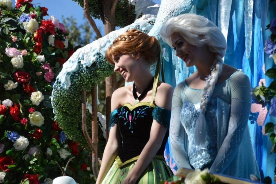 Frozen characters Ana and Elsa smile to Disney-goers at a parade