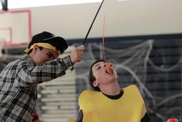 Strings junior Jorge Plaza dangles a doughnut for band freshman Mark Silver as he competes in the Fall Festivals doughnut eating race during lunch on Friday, Oct. 30.  