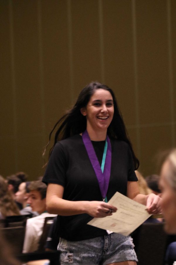 Communications junior Tom Kapitulnik returns from accepting her Superior award for the News Editing/Headline Writing Write-off.