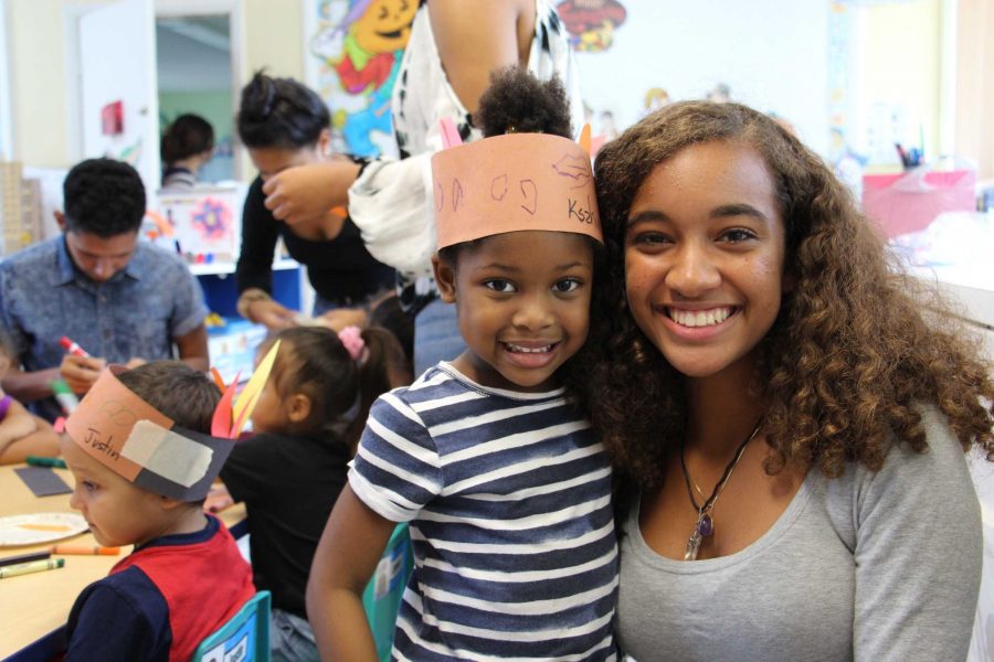 Vocal sophomore Madison Cuellar (R) and members of the Latin-Hispanic Heritage Club visit the New Pines Development Center for an arts and crafts activity with three-year-old children. The club made hats and goodie bags with the kids.