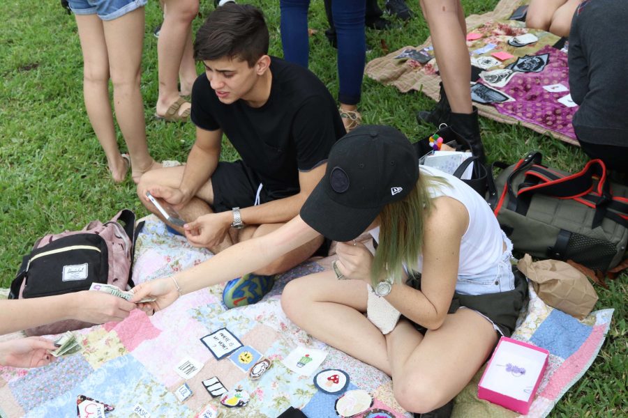 Digital media seniors Mason Schuessler (L-R) and Eden Manresa sell sell Manresas artwork at todays art sale on freshman hill. I started making my angel babies last year for fun. People asked me to make custom ones for them so this year I thought I would sell them at the art sale. I have troll babies, angel babies, and babies in hula skirts for people to buy, Manresa said.