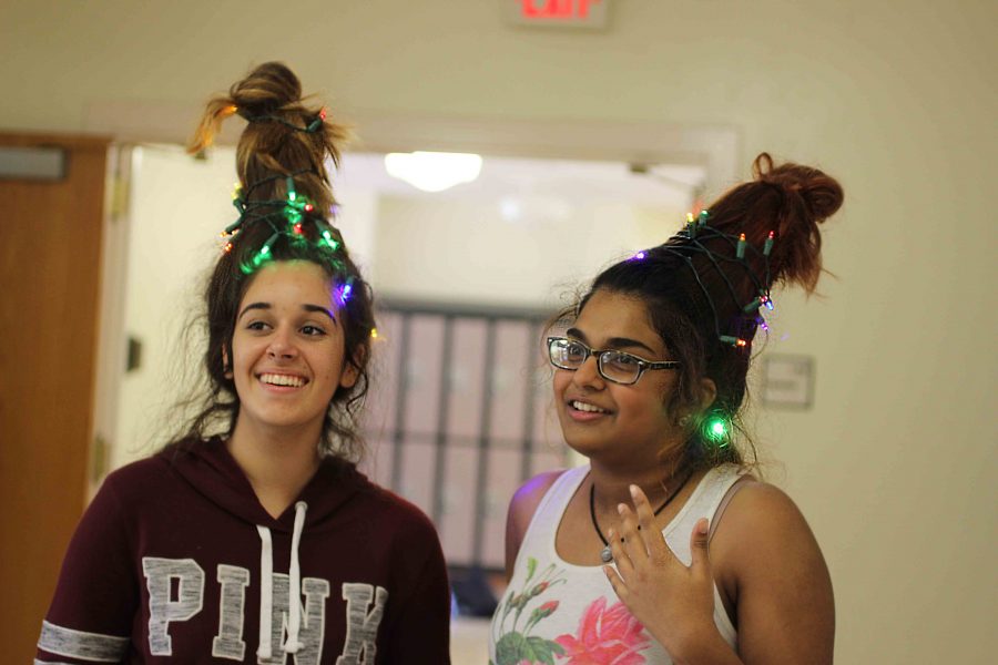 (L-R) Communications freshmen Madelyn Perera and Kavyasree Chigurupati adorn Christmas light updos to celebrate the beginning of the holiday season. 
We did it because Christmas starts Dec. 1, Perera said. Their hairstyles were supported by water bottles and hair ties. 