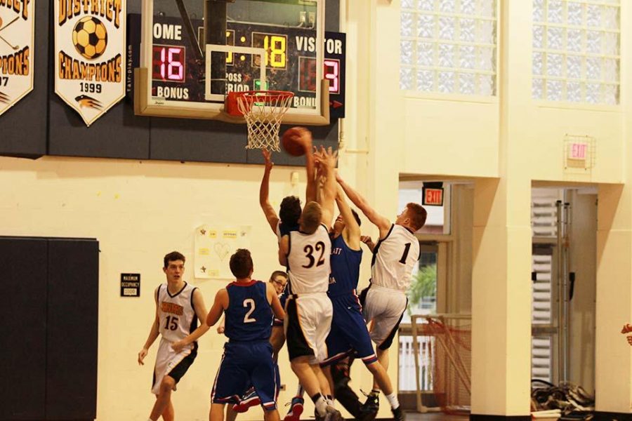 Communications junior Oscar Hamilton (left), visual sophomore Aaron Crawford (middle), and band junior Derek Brown (right) defend against the opposing team Donna Klein Jewish Academy in a game on Dec. 7 that featured a 64-60 Dreyfoos win in their home court.