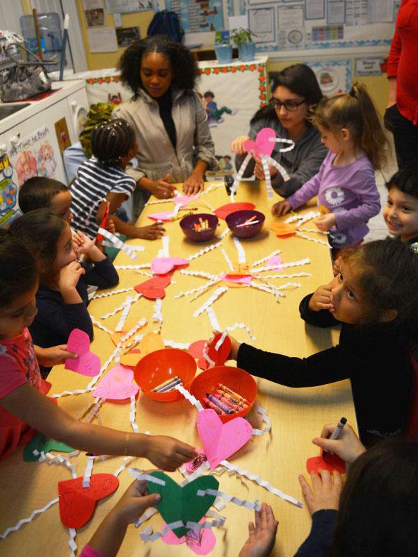 Communications junior Britania Cameron (left) and theatre junior Krystina Toledo make heart-shaped crafts for 4-year-old kids at the New Pines Development Center in West Palm Beach. Toledo and Cameron attended the trip with the Latin-Hispanic Heritage Club during lunch. 