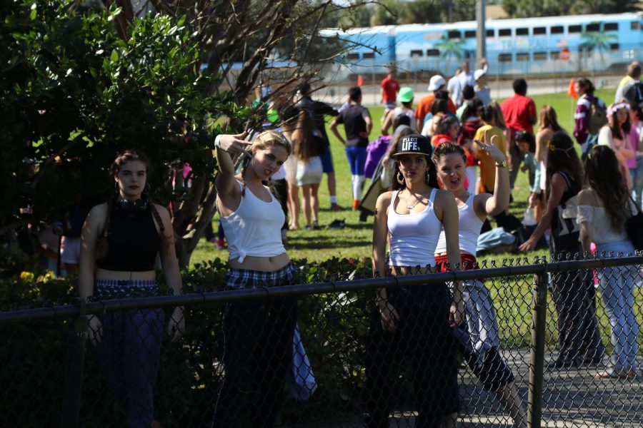 Visual senior Nicole Lindner (L-R), theatre senior Melissa Knoop, digital media senior Tiffany Barron, and vocal 
senior Hadley Bouchlas throw up peace signs during the Genre Day kickball game.