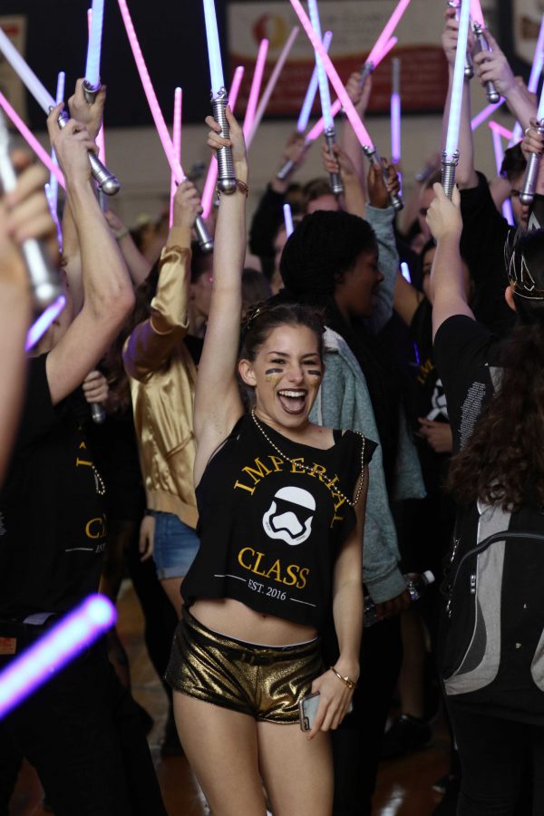 Lightsaber in hand, theatre senior Ally Scirrotto cheers with the senior class during their entrance at the Pep Rally.