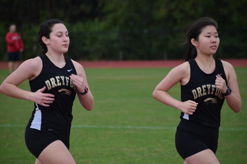 Communications senior Naomi Kelly (L-R) runs along visual senior Heather Hart at the track and field teams first meet of the season. The meet took place at The Benjamin School and some of the events such as the field events were cancelled due to the rain. 