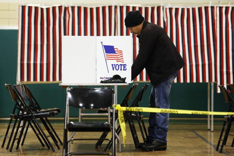 A voter marks his ballot in the first-in-the-nation presidential primary, Tuesday, Feb. 9, 2016, in Nashua, N.H. 