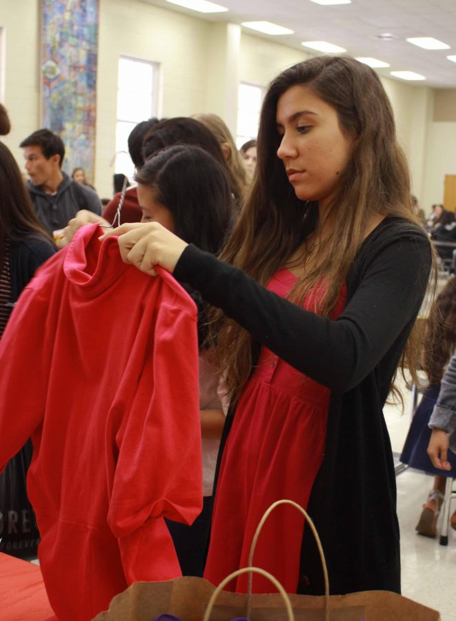 Communications junior Anthea Simon places a dress on a hanger as part of the Womens Empowerment Clubs Dress Collection Party. Girls can donate their lightly used prom dresses, shoes, and accessories .  