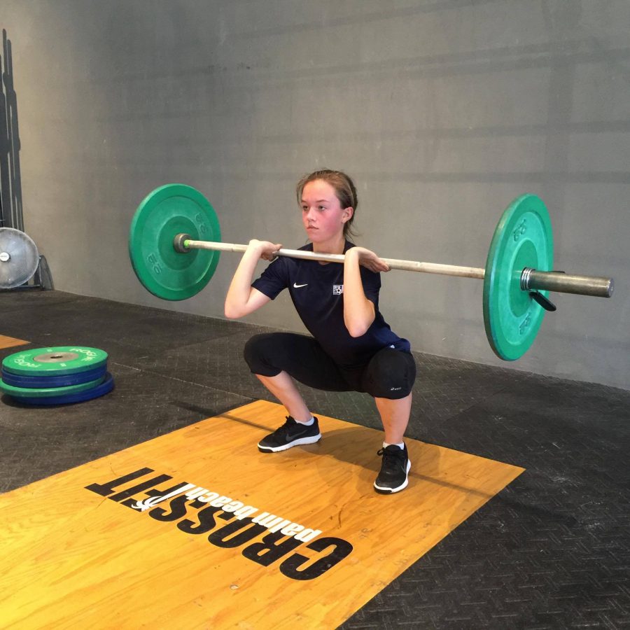 Theatre junior Ashton Royal performs a push press and a front squat at her Crossfit gym. Royal typically works out two to three times a week.