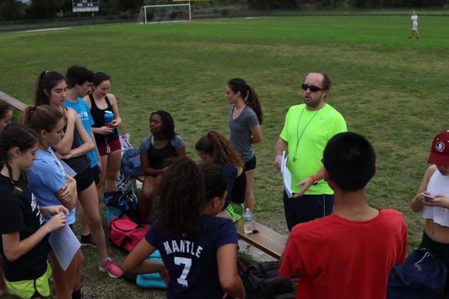 Social studies teacher and Athletic director Ross Vening stands with team members at Forest Hill High School, the new location for practice that Mr. Vening has implemented this year. Mr. Vening reviews with his players their events for the teams next meet on March 8 at William T. Dwyer High School.