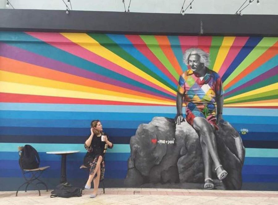 Communications junior Hannah Dunn lounges with a cup of coffee next to the newly painted mural at Subculture Coffee. It is located on 509 Clematis Street, just several blocks away from school. 