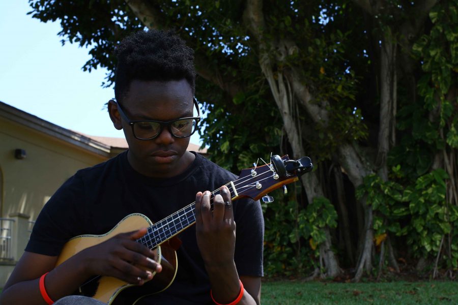 Visual freshman Jeremy Greenly plays his ukulele in the shade of the banyan tree on Freshman Hill.  Ive been playing the ukulele for about a year, Greenly said. I like it because its relaxing and fun.  