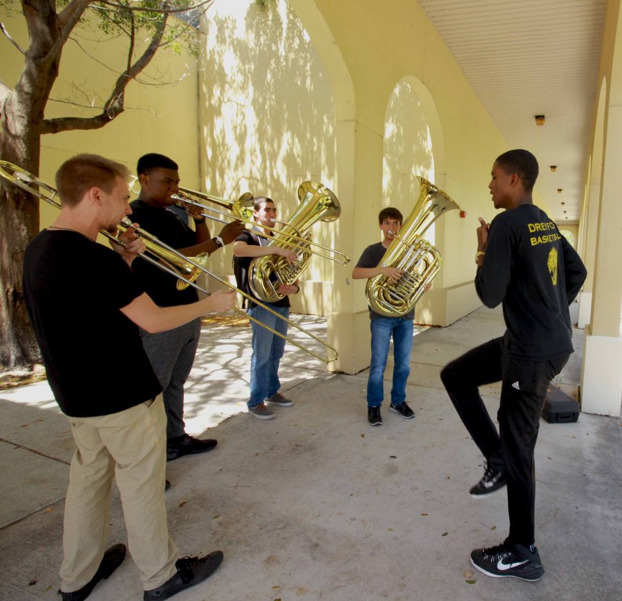 (L-R) Band senior Tyren Woods dances to music made by band juniors Kyle Virtue, Yoel Lugones, Kaleb Marshall and senior Triton Payne. The four practiced outside building 7. 