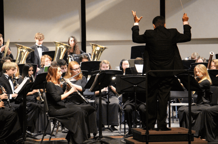 Band director Evan Rogovin stands with his back to the crowd as he conducts the Symphonic Band’s performance of “Undertow,” a number by John Mackey. 