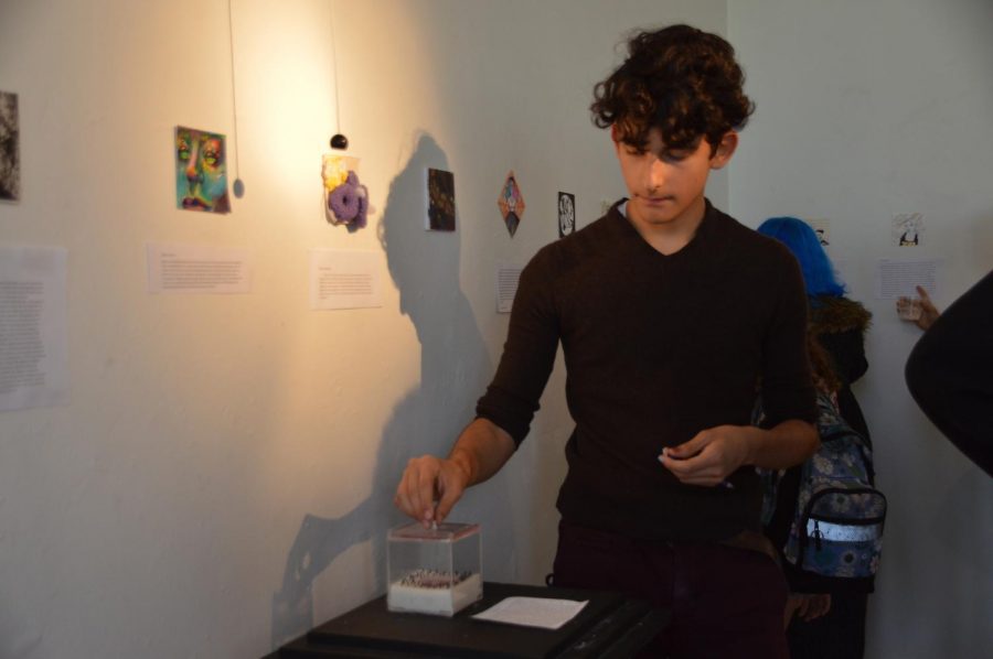 Visual senior Dan Mitrovic examines an interactive piece in the 4x4 art show on April 1.
