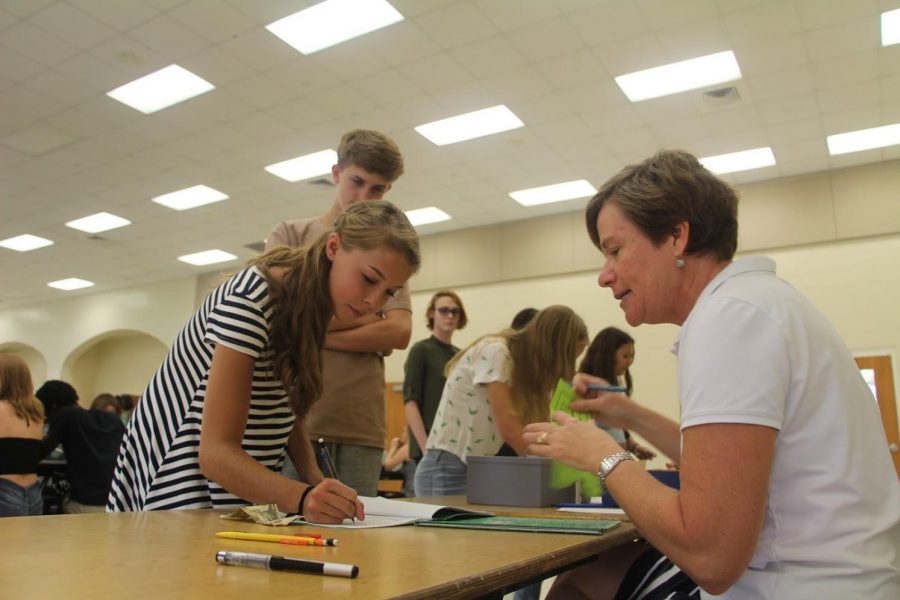 Communications sophomore Elizabeth White purchases her locker for the year from volunteer, Mrs. Fullop in the cafeteria. 

Its fun to interact with the kids in the first week of school, said volunteer, Mrs. Fullop. 

Lockers will be available for purchase throughout the first week of school.