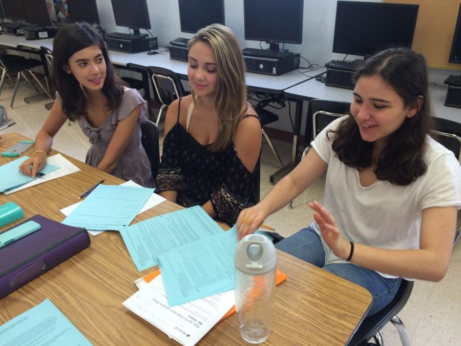 Communications juniors Ashley Brundage (L-R), Morgan Scott and Ruby Rosenthal flip through their Muse syllabi in preparation for the upcoming school year. The Muse staff members are excited to bring new stories to the new school year.