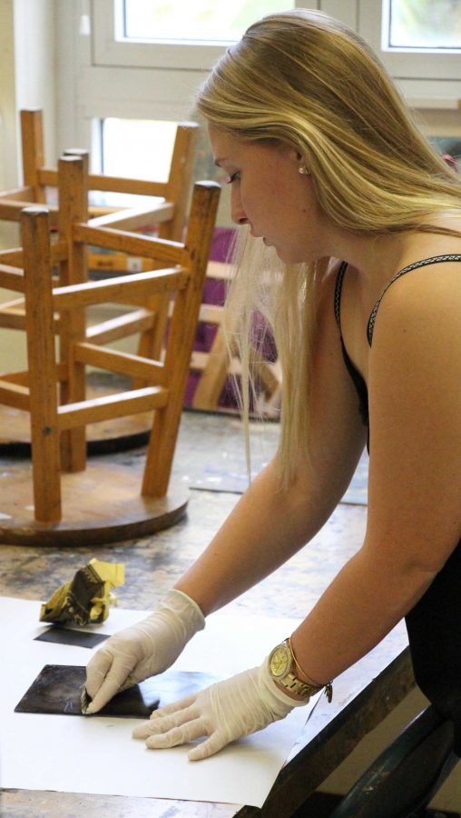 Communications senior, Stephanie Hartman prepares her drypoint etching for a test print during AP 2-D.