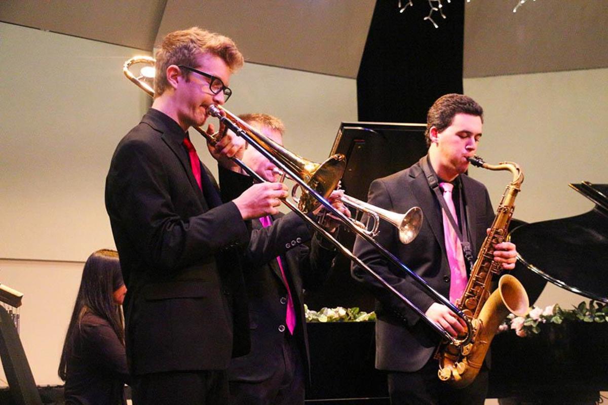 Band sophomore Leo Markel plays the trombone (L-R), band senior Ian Press plays the trumpet, and band junior Austin Klewan plays the saxophone to Autumn Leaves during the preshow.