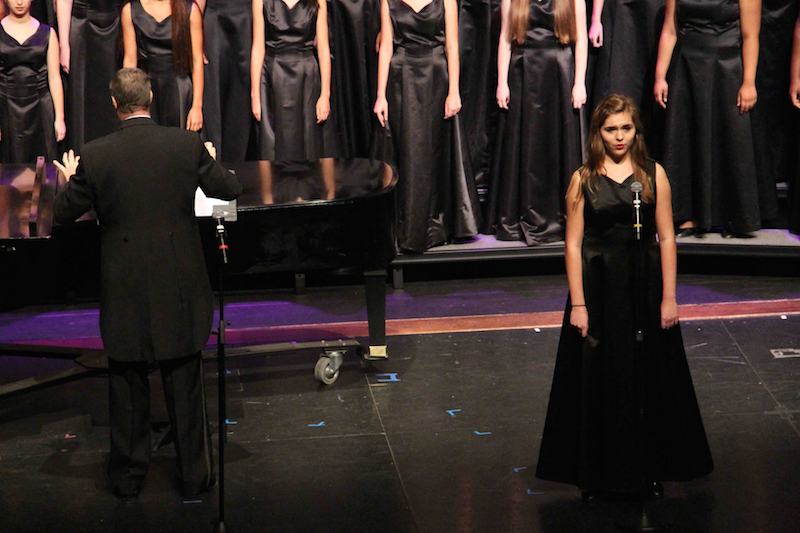 Vocal junior Ashlyn Taylor performs a solo during “Wood River,” by Willi Zwozdesky, while vocal dean Ken Taylor directs the chorus to sing background notes. 