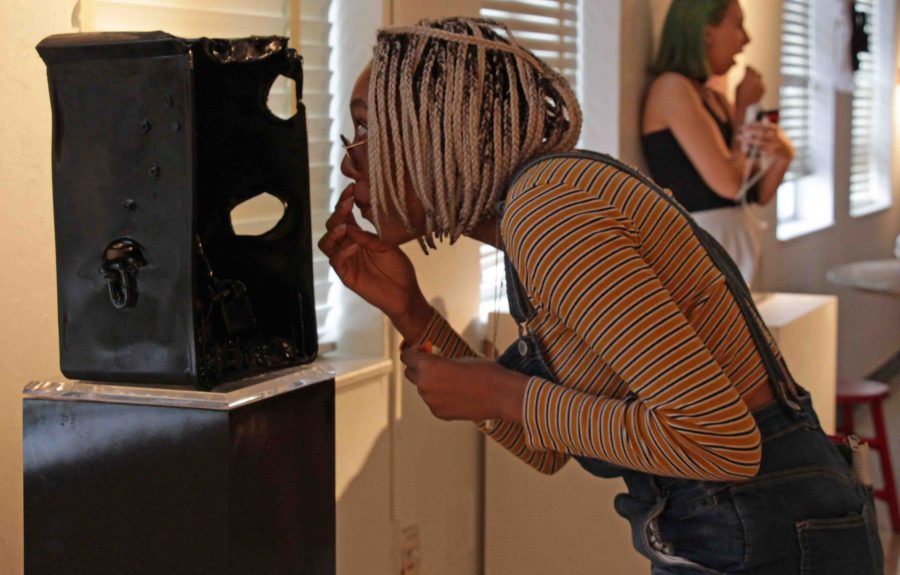 Digital junior Ashley Prather looks at an art sculpture during the Grosstober Art Showcase on Oct. 27.