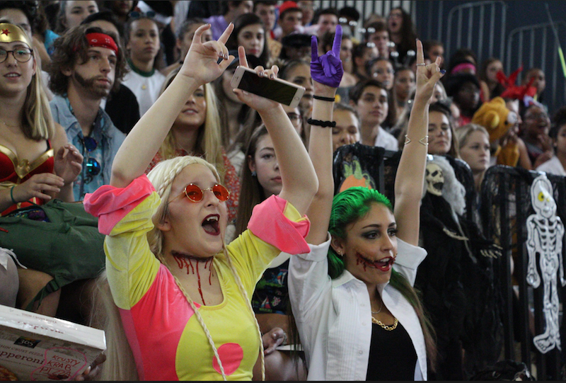 Theatre seniors Danielle Francois and Krystina Toledo cheer on their grade at the Fall Festival in the gym.