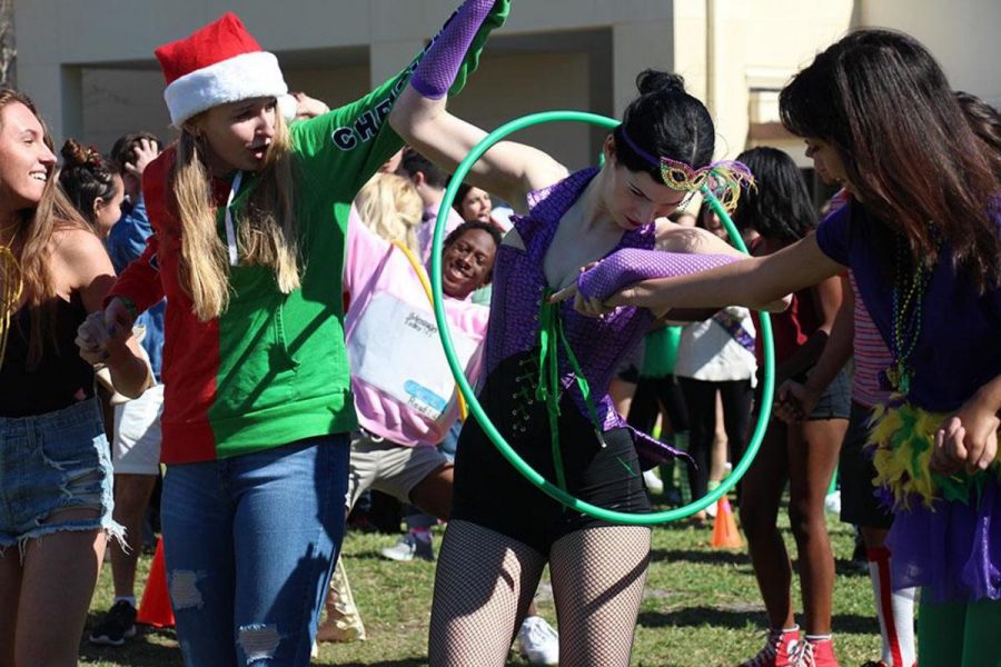 Theater senior Alexandra Chicco passes the hula hoop through her arm in the hoop chain challenge. 