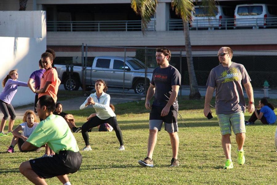 Track and field coaches, social studies teacher Ross Venning and math teacher Craig Adams, start to round up the team as they go through stretches during conditioning.