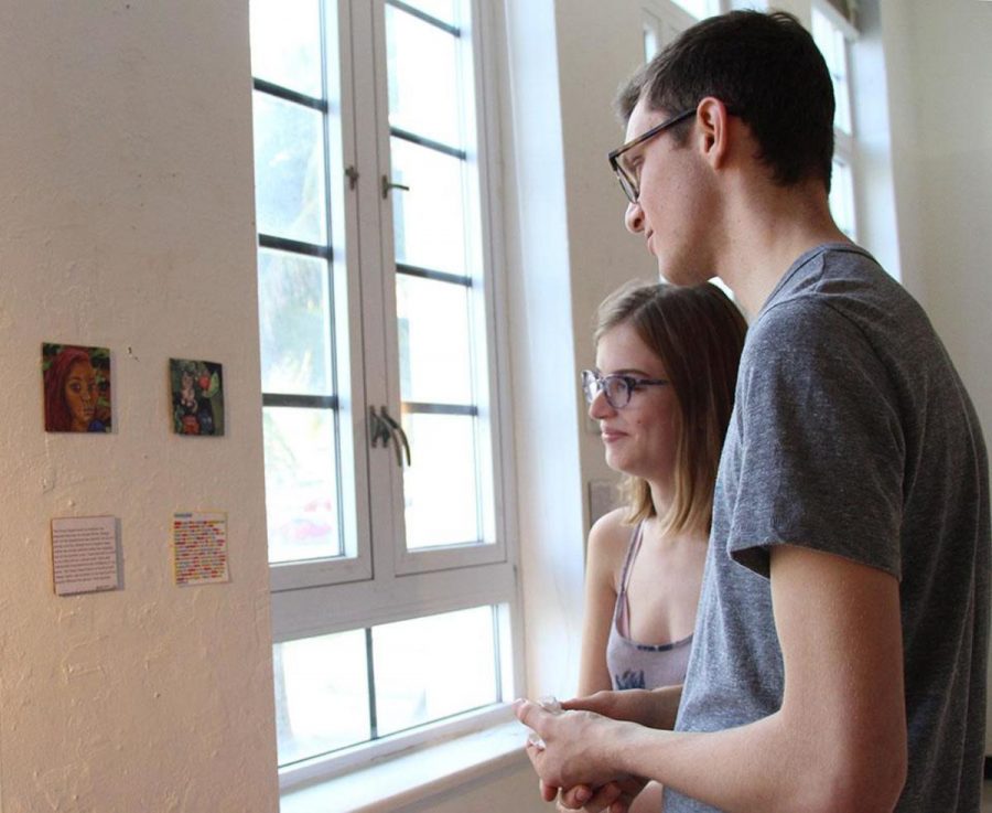 Visual senior Bailey Triggs and communications senior Matt Nadel view the art presented in the 4x4 Show held in the Building 9 gallery on Jan. 17.