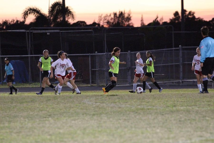 Strings senior and team captain Sarah King heads toward the ball to receive a pass from her teammates while surrounded by girls from the opposing team.