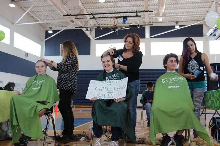 Visual sophomore Bridget Amico, communications junior Gina Givens, and theatre junior Ethan Izenwasser sit and get their head shaved at the annual St. Baldrick’s event held on Feb. 9 in the gym. 