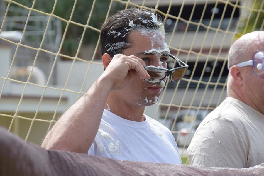 Science teacher Stephen Anand takes off a pair of protective glasses after getting pied during Math Honor Societys Pi Day celebration.