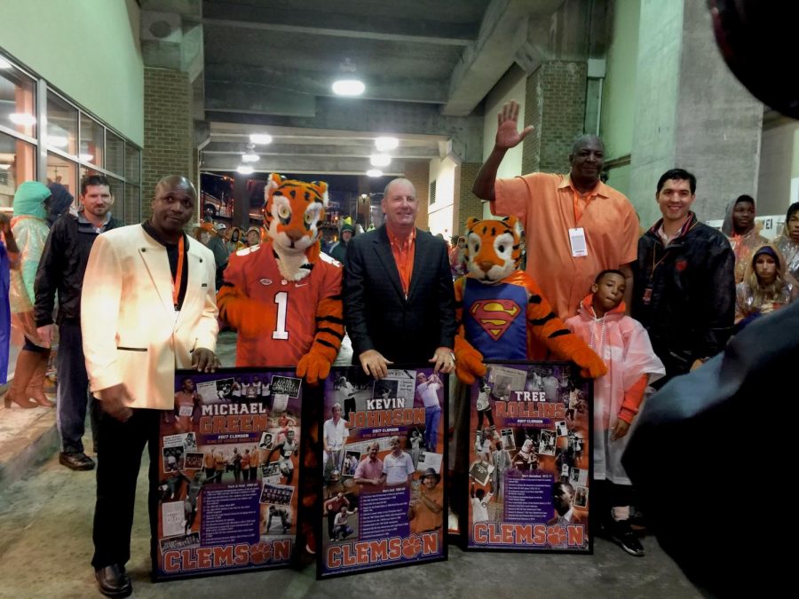 Clemson University’s Ring of Honor inductees, Michael Green, Kevin Johnson, and Tree Rollins stand with the Tiger mascots and face the cameras as they’re shown with their awards. Moments before the three inductees ran onto the field to dot the “i” in the word, “Tigers” spelled out by the band, their images appeared on the jumbo screen before the football game against Georgia Institute of Technology on Oct. 28, 2017.