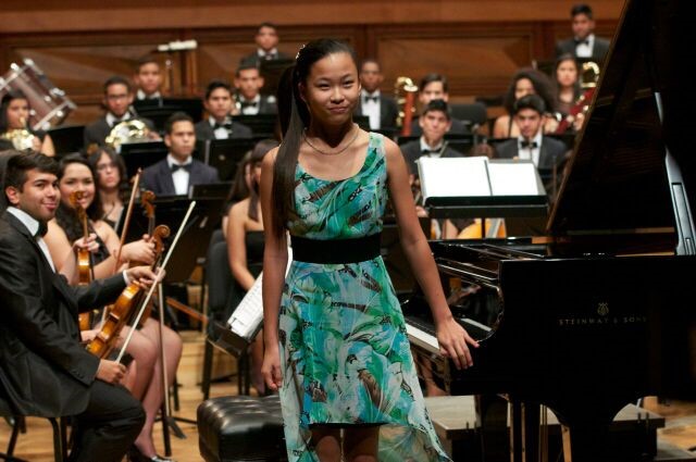 Piano junior Alessandra Fang stands to be recognized after performing along with a live orchestra. Fang was chosen to travel to Venezuela in 2014 to showcase her talent. 